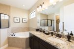 The en-suite bathroom has a dual vanity, walk-in shower, and garden tub